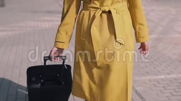 戴着黄色雨衣帽和眼镜的漂亮女孩带着行李视频的预览图