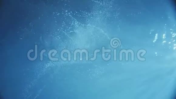 在水下摄像机下一位女士穿着一件黑色的衣服跳进黑暗的水中开始游泳晒太阳视频的预览图