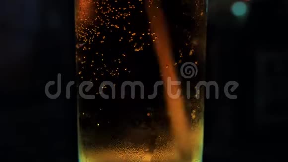 慢镜头混合苏打水与鸡尾酒吸管在玻璃浅深的领域微光镜头视频的预览图