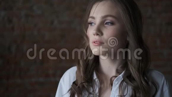 一个穿白色衬衫特写的漂亮女孩的肖像漂亮的蓝眼睛模特看着相机视频的预览图