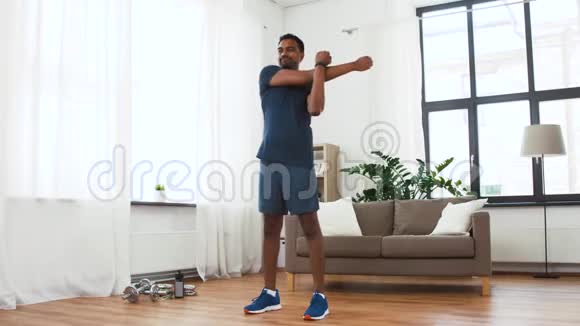 有健身追踪器的男人在家伸展身体视频的预览图