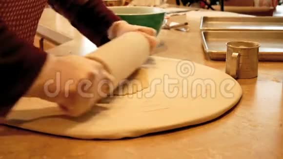女人在厨房柜台上用擀面杖擀制饼干面团视频的预览图