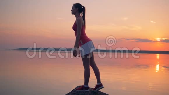 一位美丽的女士在湖边锻炼身体视频的预览图