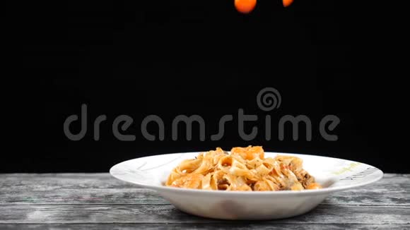 慢动作做饭樱桃西红柿落在盘子里上面有美味的意大利面用高速相机拍摄烹饪视频的预览图
