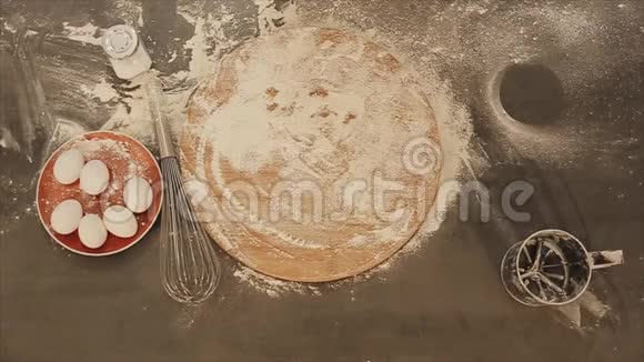 从上面看女性手的特写把新鲜的面包放在桌子上面粉散落在周围鸡蛋放在红色的视频的预览图