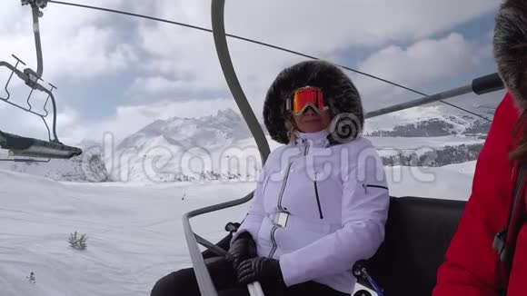 滑雪者爬上椅子抬到山顶挥手致意视频的预览图
