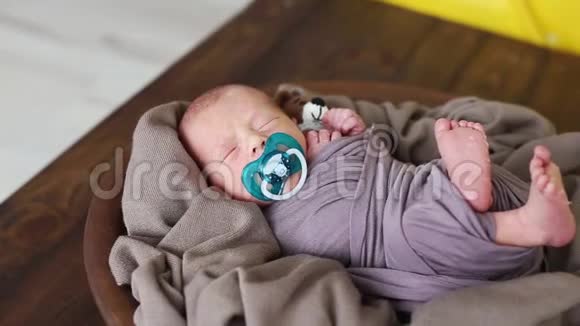 刚出生的男孩睡在一个盘子里铺着一块棕色的布移动他的脚视频的预览图