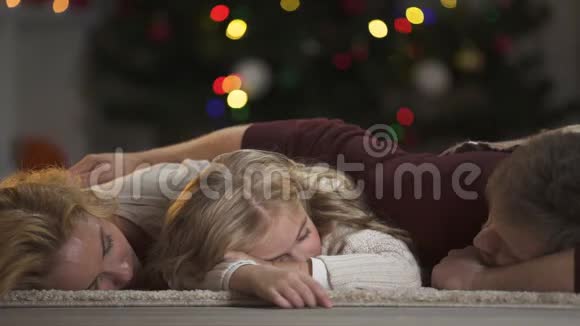 一家人睡在圣诞树下等待圣诞老人相信魔法视频的预览图