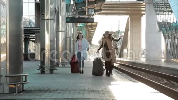 火车站三个女人带着行李在站台上匆忙地坐火车视频的预览图