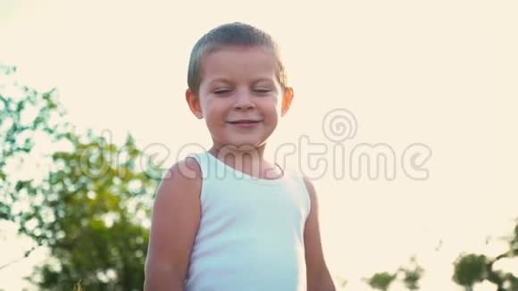 四岁的男孩穿着一件白色的t恤笑着孩子跳起来在他的手指上展示全班同学活泼开朗的肖像视频的预览图
