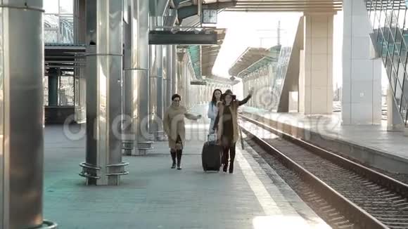 火车站三个女人带着行李在站台上匆忙地坐火车视频的预览图