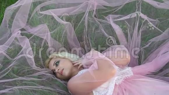 美丽的少女躺在白花丛中的空地上视频的预览图