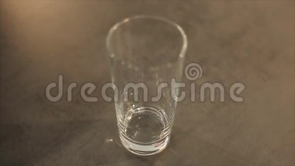 一杯溢出的牛奶牛奶倒过玻璃杯灰色桌子上漂亮的玻璃酒杯从上面看视频的预览图