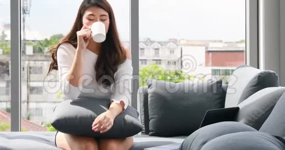 拿着咖啡杯和笔记本电脑的亚洲妇女视频的预览图