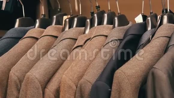 在商场的一家男士服装店一排暖男夹克衫在衣架上各种男士西装挂在购物中心视频的预览图