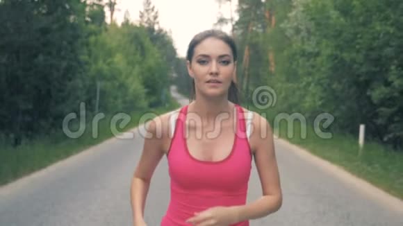 一位漂亮女士沿着小巷慢跑的慢镜头健康苗条的年轻女运动员跑步视频的预览图