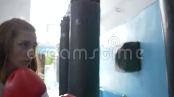 拳击场上戴手套的运动员用拳击袋打得紧紧的视频的预览图