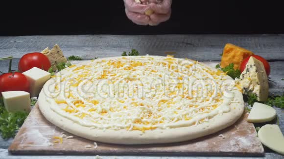 厨师的双手特写在木板上加入四个奶酪比萨饼中的蓝色奶酪框架美味的披萨视频的预览图