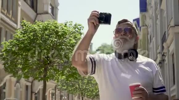 戴墨镜的时尚成熟男人的肖像在城市拍照视频的预览图