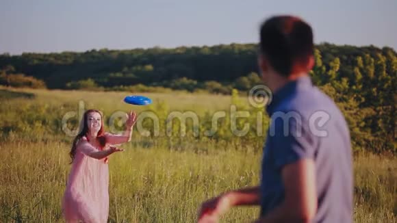 快乐的一对夫妇在阳光明媚的夏日玩飞盘视频的预览图