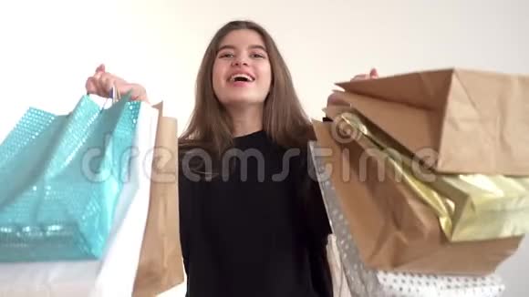 美丽的女孩微笑着拿着购物袋惊讶不已零售连锁店库存视频的预览图