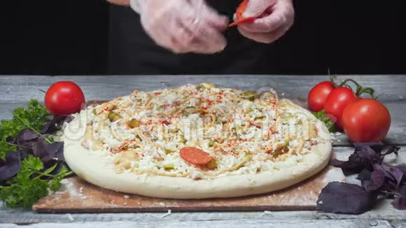厨师的手戴着硅胶手套在靠近西红柿欧芹和罗勒的披萨上放上萨维洛框架视频的预览图