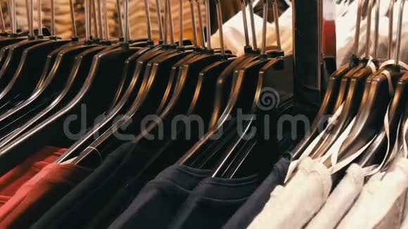 许多不同颜色妇女的衣服挂在衣架上躺在一家服装店的货架上视频的预览图