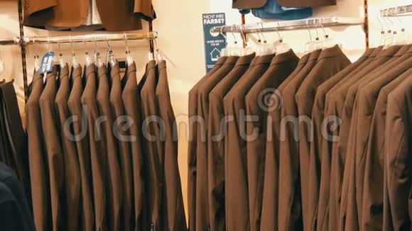 在商场的服装店里同色西装挂在衣架上的男人的数量视频的预览图