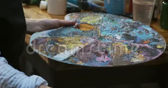 在木调色板上用女性手混合油彩有魅力的女孩创造了现代艺术绘画接近女性视频的预览图