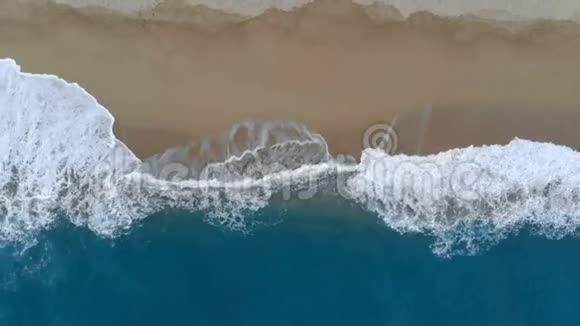 从泡沫波和沙质海岸上方看视频的预览图