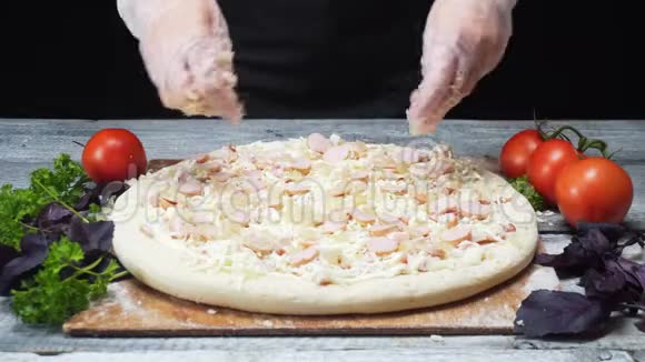 厨师用硅胶手套将奶酪加入木桌上的披萨框架美味的披萨视频的预览图