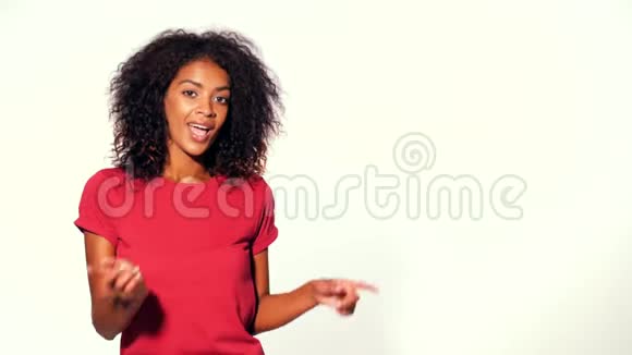 快乐微笑的非洲女人在红色顶部呈现和展示一些孤立的白色背景女孩肖像视频的预览图