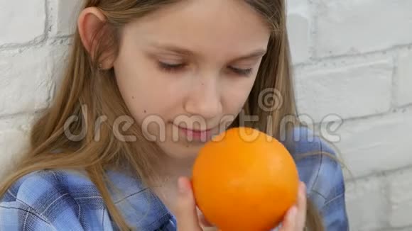 儿童早餐吃橘子水果女孩闻健康食品厨房视频的预览图
