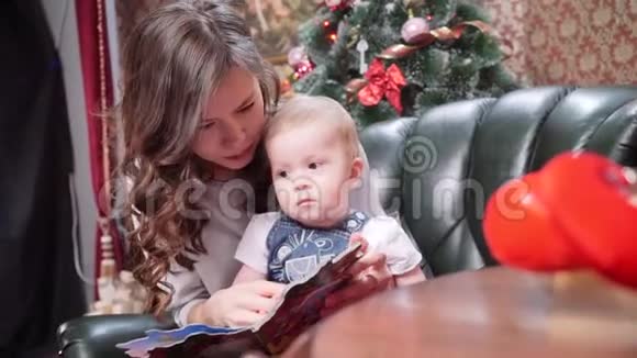 一位年轻的母亲给她的小儿子读圣诞故事圣诞快乐节日快乐视频的预览图