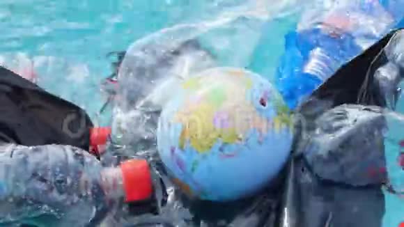 行星污染和不可回收废物的概念地球仪漂浮在塑料垃圾中视频的预览图