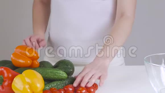 女人选择蔬菜做沙拉在桌子附近跳舞手里拿着两个鳄梨视频的预览图