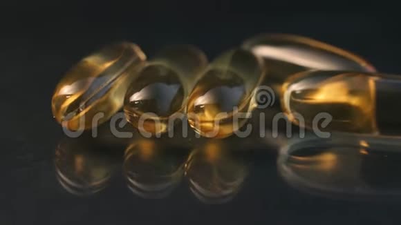 药片药片鱼油欧米茄3黄色反光背景反色生物添加剂视频的预览图