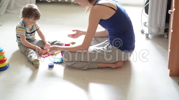 小宝宝和妈妈在白地板上玩耍视频的预览图