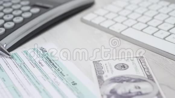 在电脑键盘和计算器旁边的桌子上女人计算税和数钱的特写滑块镜头4k视频的预览图