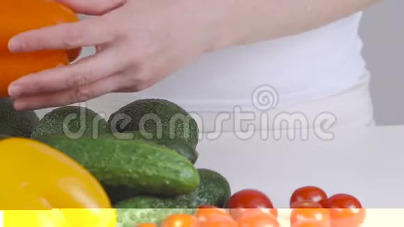 一位妇女拿起蔬菜在桌上旋转鳄梨视频的预览图