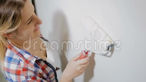 漂亮的年轻女人在翻新她的新公寓年轻女孩在房间里画墙视频的预览图
