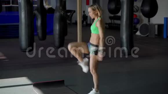 强壮和健康的美丽女孩在运动顶部是做蹲操在拳击健身房视频的预览图