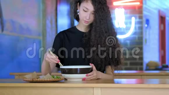 漂亮的亚洲女人在智能手机上自拍年轻的亚洲女孩在咖啡厅与pho汤拍照中文视频的预览图