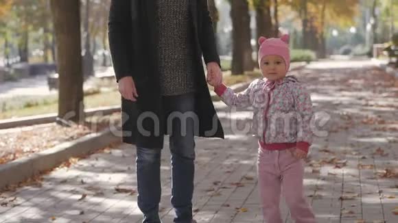 妈妈牵着小女儿的手在秋城公园散步视频的预览图