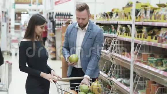 正面视频年轻夫妇女人在超市用水果做滑稽的脸视频的预览图