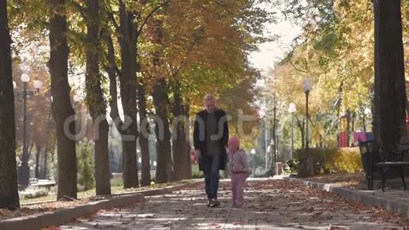 妈妈牵着小女儿的手在秋城公园散步视频的预览图