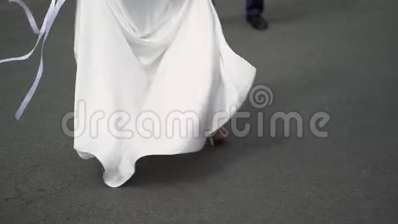 年轻的新娘穿着婚纱在一个城市盘旋白色豪华礼服视频的预览图