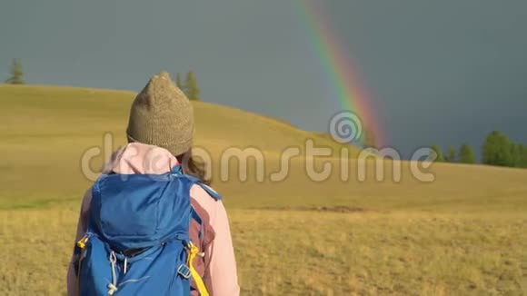 女人徒步旅行在山上远足带背包的女旅行者在美丽的夏季景观上一个女孩走进来视频的预览图