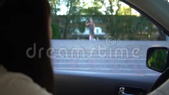年轻的母亲坐在车里等女儿放学视频的预览图
