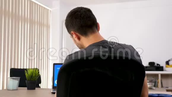 客厅里人的后视图看着电脑屏幕上面有动画金融图表视频的预览图